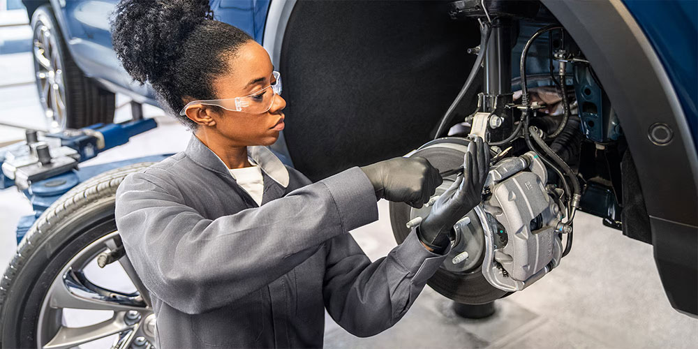 A technician working on the Brake pad of a Buick model