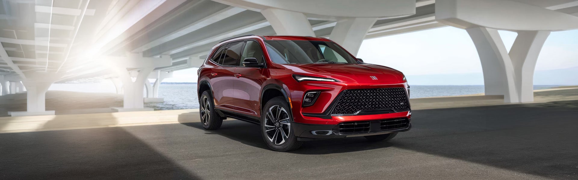 Red SUV displayed indoors in a modern showroom with sleek design and bright lighting.