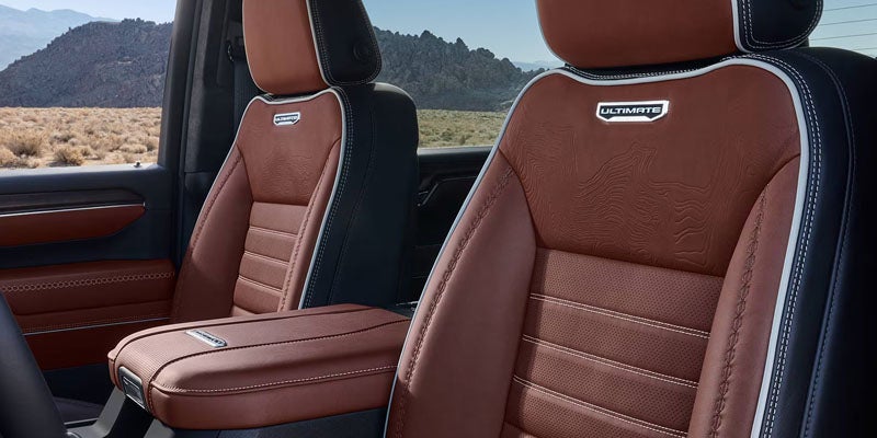 Premium vehicle interior featuring brown leather seats with detailed stitching and a luxury cabin design.