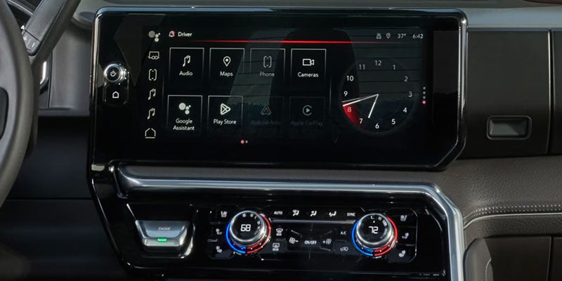 Vehicle dashboard featuring a large touchscreen infotainment system, digital controls, and climate settings.