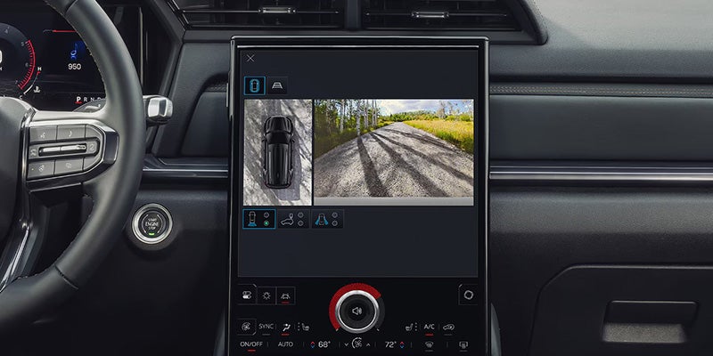 Vehicle infotainment screen displaying a camera view of a road, integrated into a modern car dashboard.
