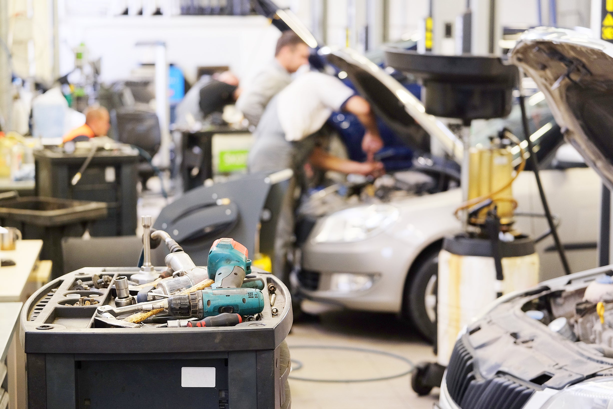 Automotive technicians performing vehicle maintenance in a service center